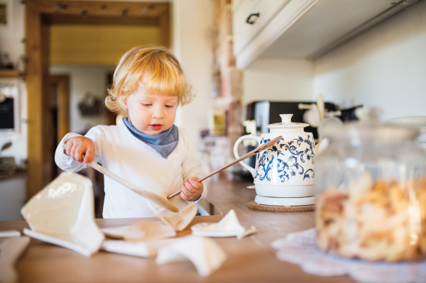 Toddler boy in a dangerous situation at home. Domestic accident. Child safety concept.