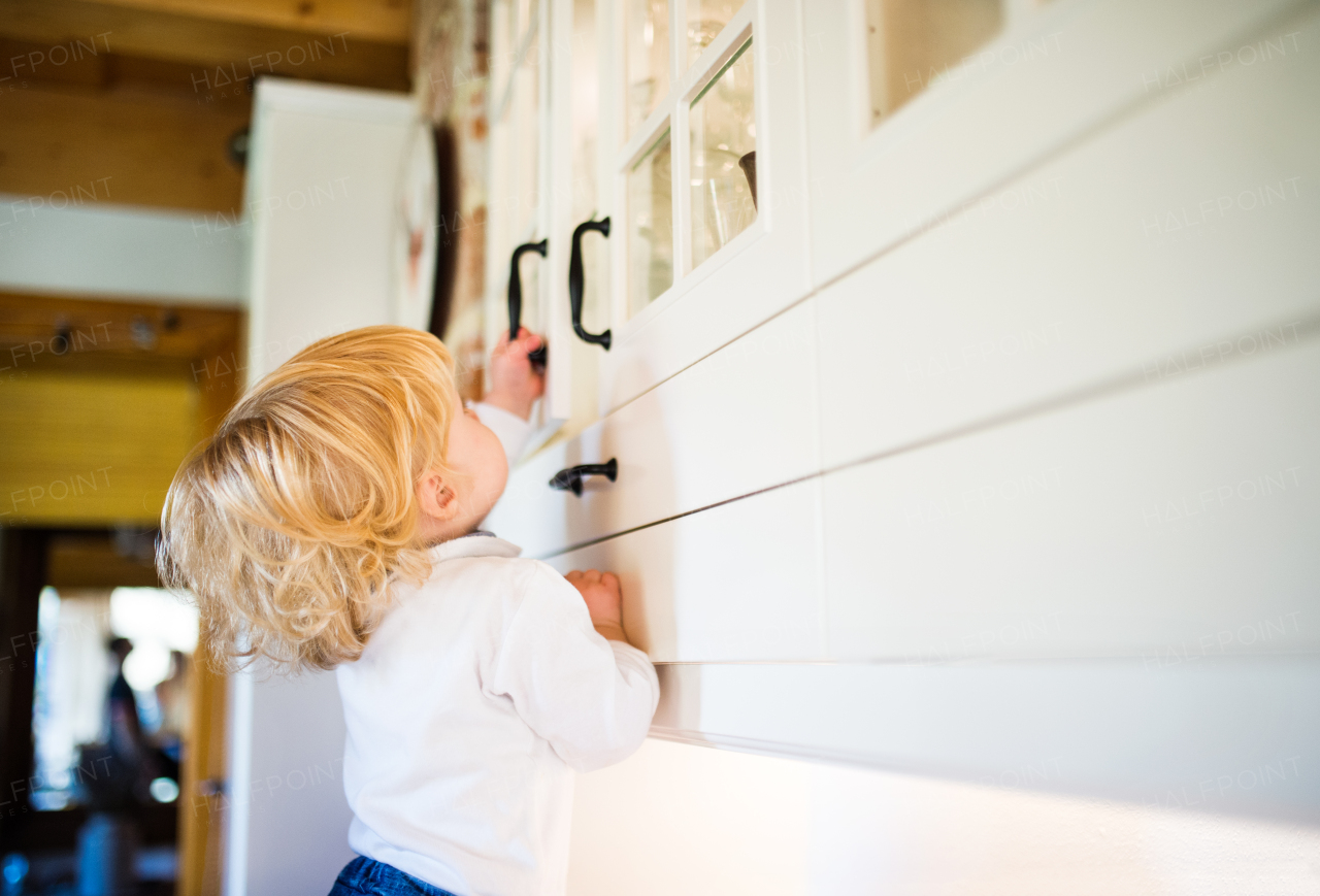 Toddler boy in a dangerous situation at home. Domestic accident. Child safety concept.