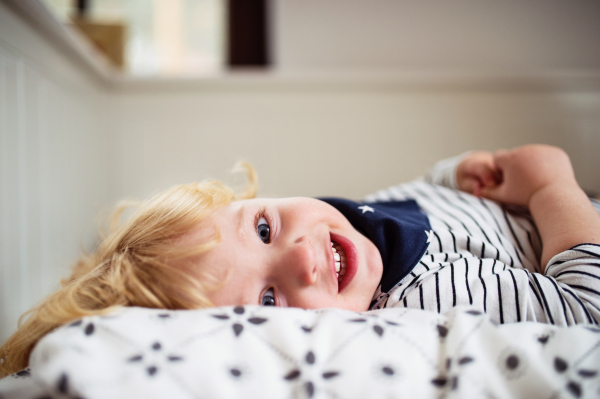 Cute toddler boy lying on the bed. Close up.