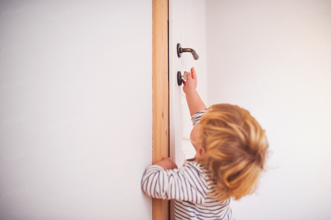 Little toddler boy locking door. Domestic accident. Dangerous situation at home.