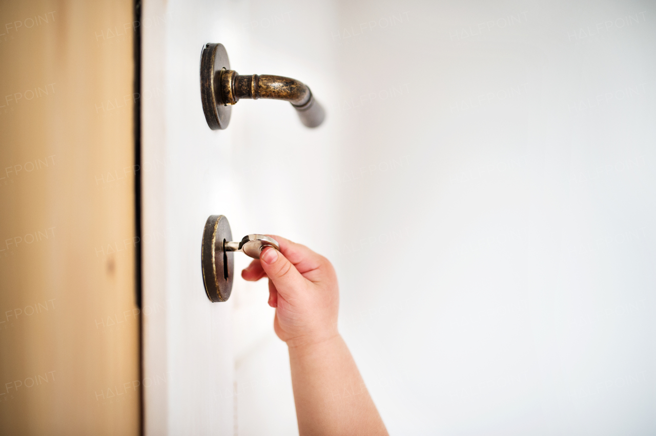 Unrecognizable toddler child locking door. Domestic accident. Dangerous situation at home.