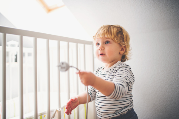 Little toddler playing with a plug. Domestic accident. Dangerous situation at home.