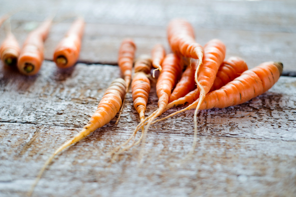 Fresh carrot vegetable laid on white wooden table background