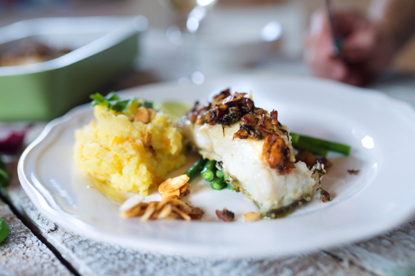 Zander fish fillet dish on a plate on a white wooden table