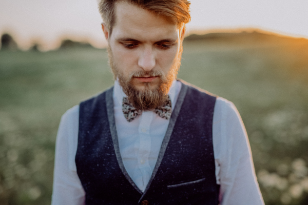 Portrait of a handsome young groom outside in nature.