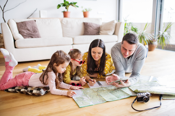 Portrait of a young happy family with two children preparing for holiday at home.