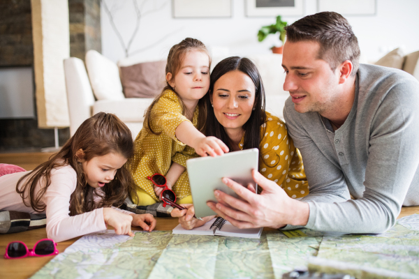 Portrait of a young happy family with two children preparing for holiday at home.