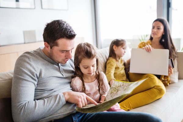 Portrait of a young happy family with two children preparing for holidays at home.