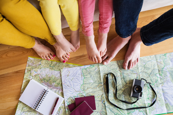 Legs of an unrecognizable young family with two children preparing for holiday at home.