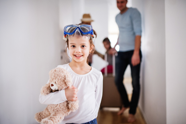 Young family with two children going on a holiday, walking through the corridor.