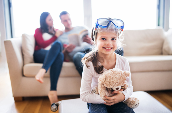 Portrait of a young happy family with a child packing for holiday at home.