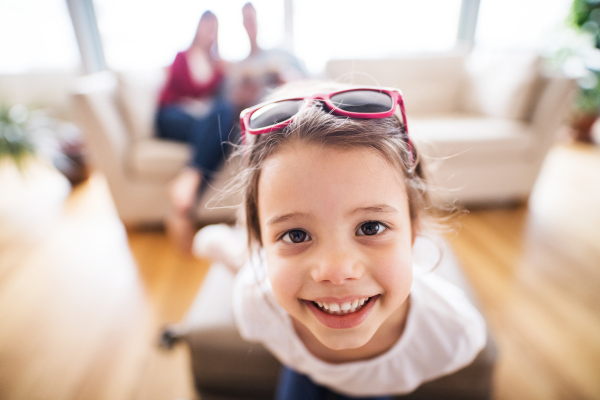 Young happy child with parents in the background packing for holidays at home.