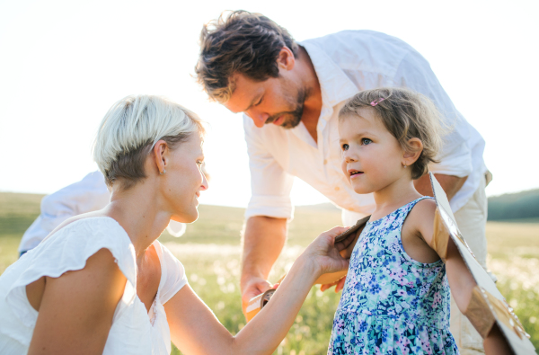 A young family with small children playing on a meadow in nature.