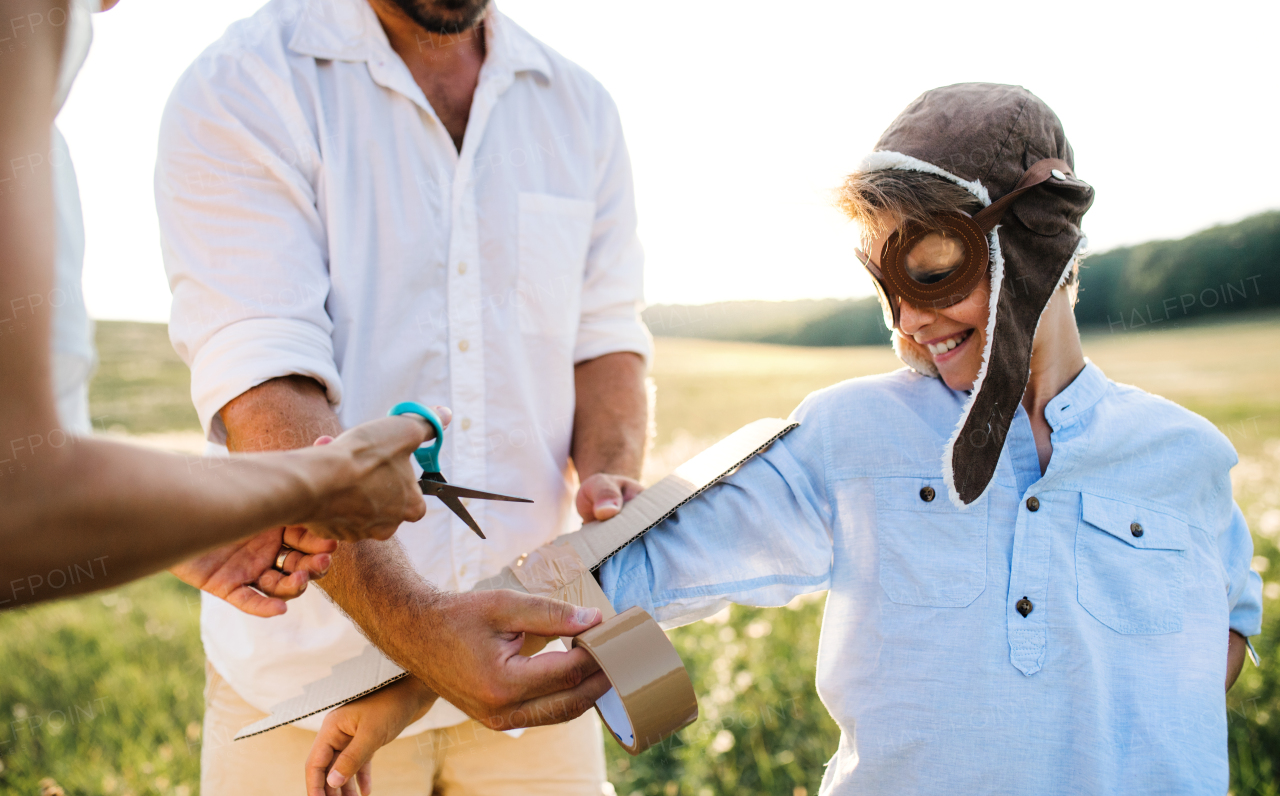 A young family with small son playing on a meadow in nature.