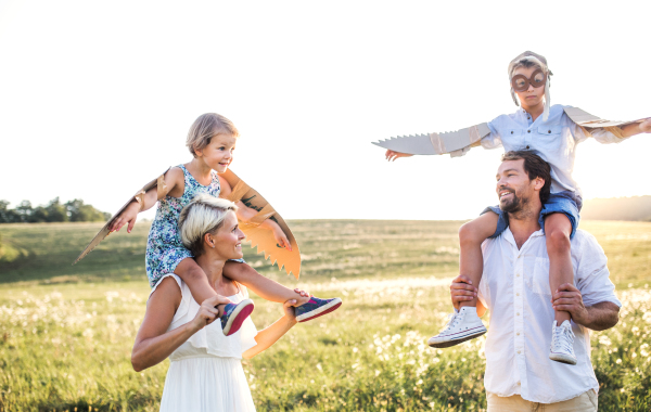 A young family with small children playing on a meadow in nature.