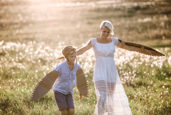 A young mother with small son playing on a meadow in nature.