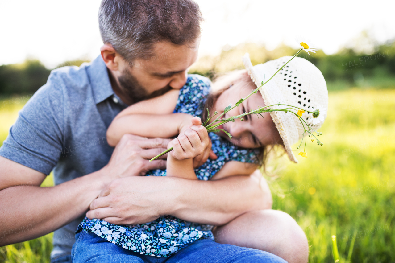 Father with a small daughter having fun in sunny spring nature.