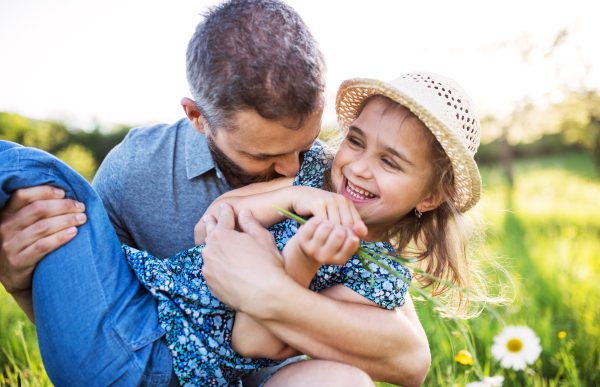 Father with a small daughter having fun in sunny spring nature.