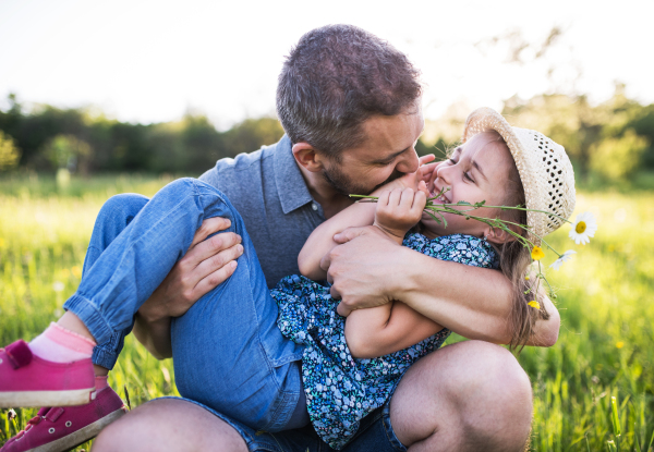 Father with a small daughter having fun in sunny spring nature.