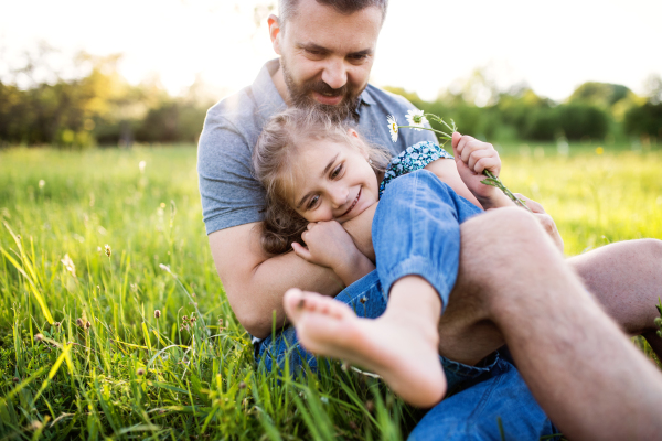 Father with a small daughter having fun in sunny spring nature.