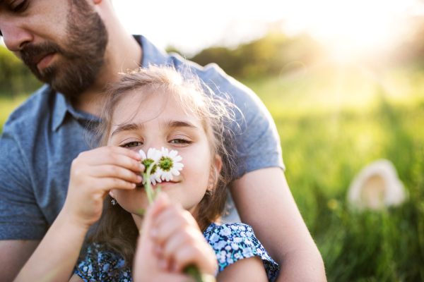 Father with a small daughter having fun in sunny spring nature.