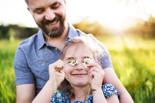 Father with a small daughter having fun in sunny spring nature.