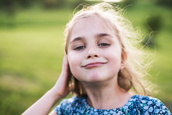 A portrait of a small girl in the garden in spring nature. Close up.