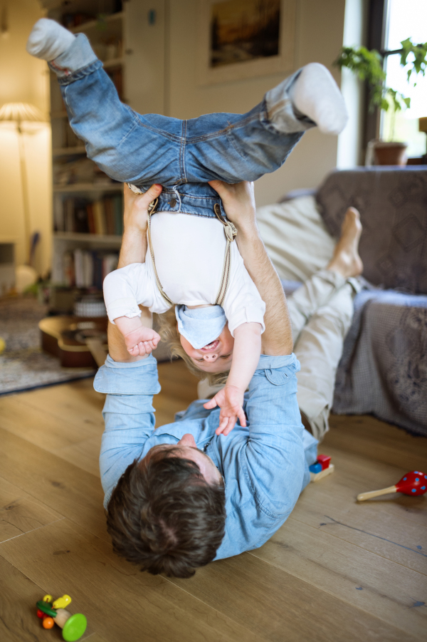 Young father with his son at home playing together.