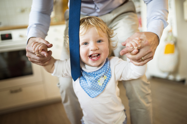 Young father with his son at home playing together.