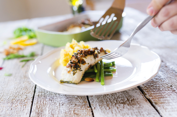 Man serving zander fish fillets on a plate