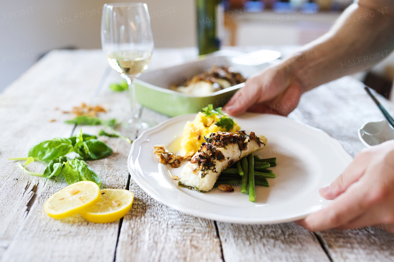 Man serving zander fish fillets on a plate