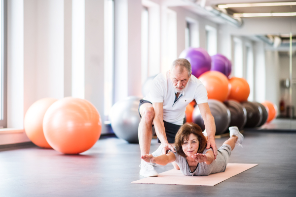 Senior physiotherapist working with an old female patient.