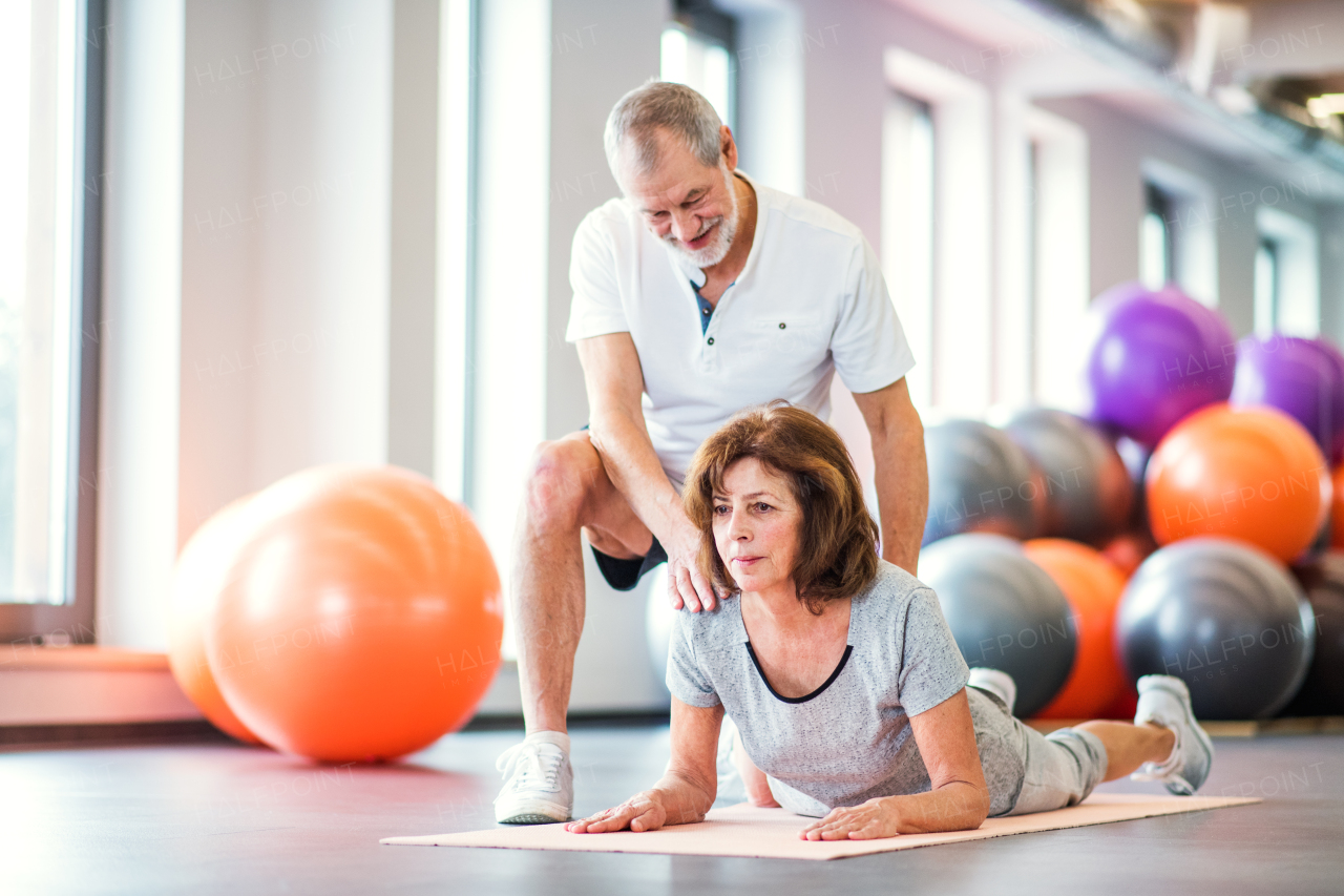 Senior physiotherapist working with an old female patient.