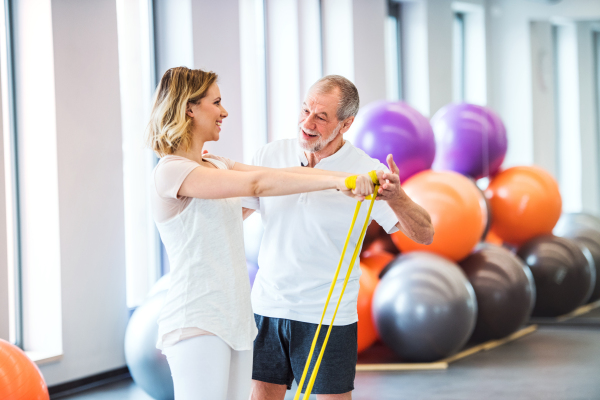 Senior male physiotherapist working with a young female patient.