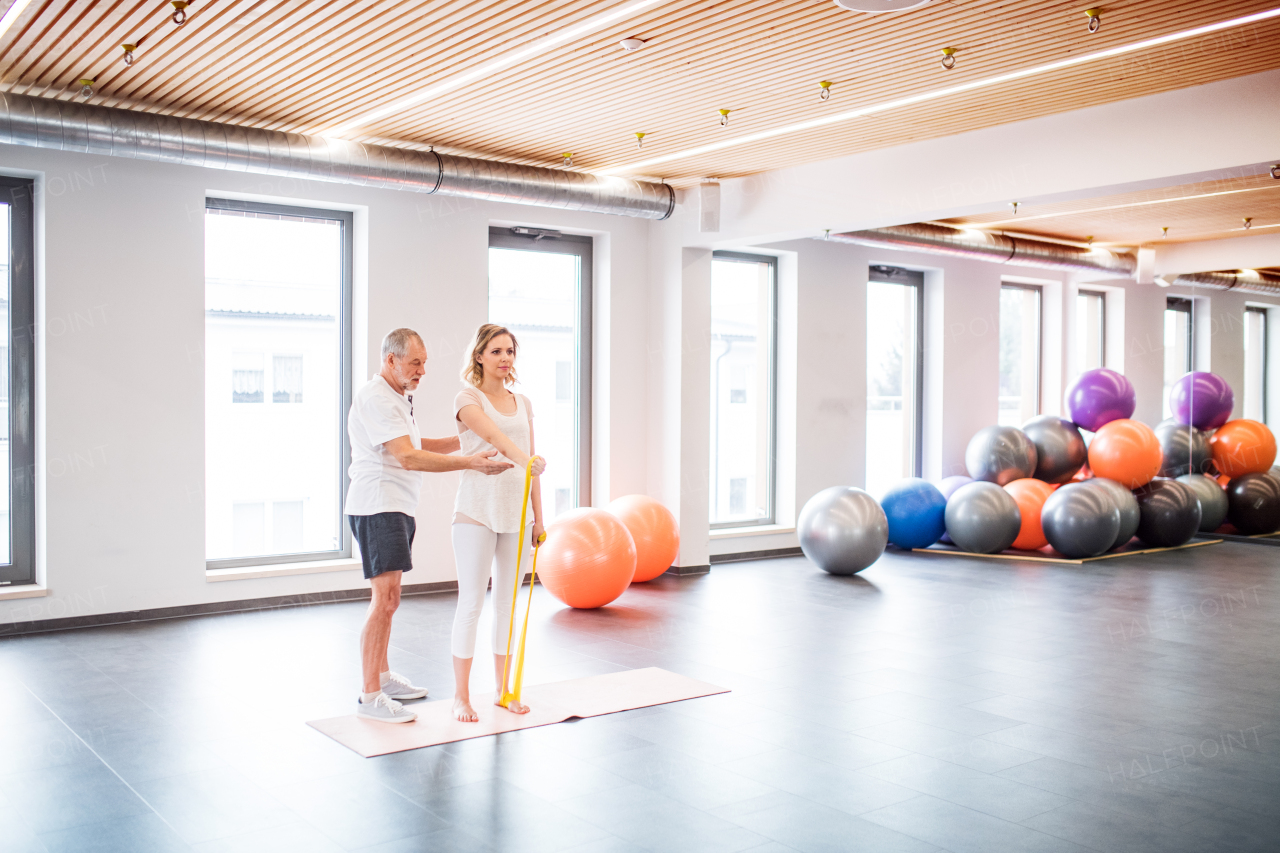 Senior male physiotherapist working with a young female patient.