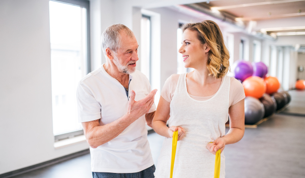 Senior male physiotherapist working with a young female patient.