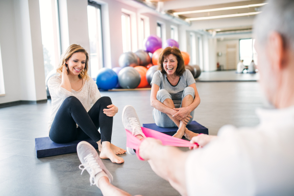 Senior physiotherapist working with two female patients.