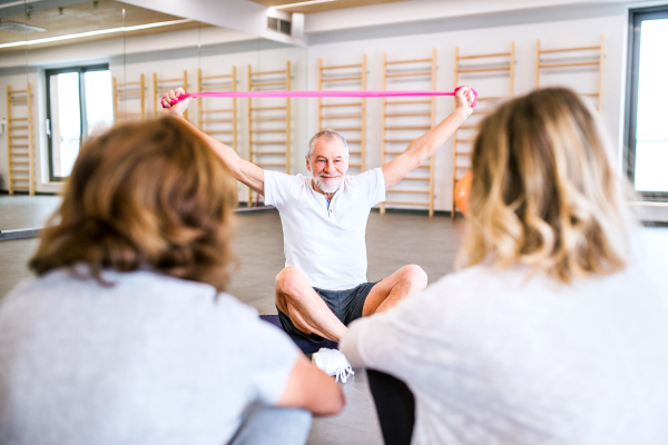 Senior physiotherapist working with two female patients.