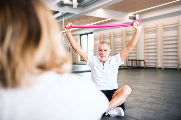 Senior physiotherapist working with an unrecognizable female patient.