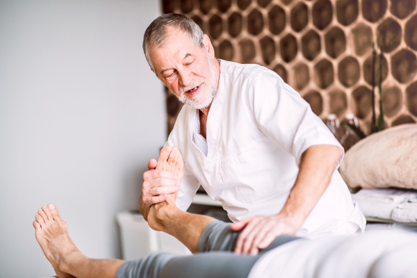 Senior physiotherapist working with an unrecognizable female patient.