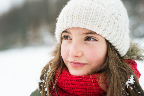 Portrait of a small girl in winter nature. Close up.