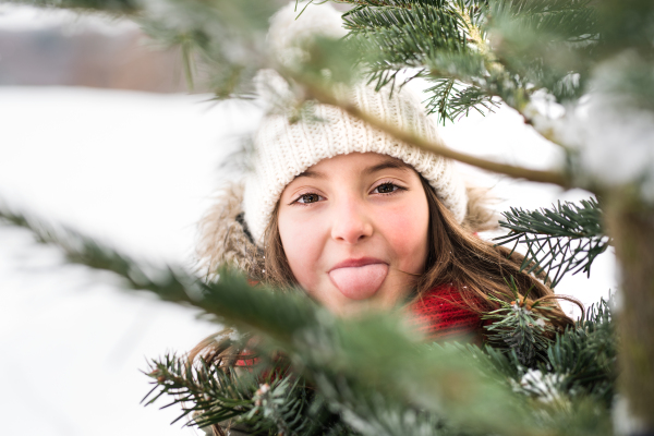 A small girl having fun in snow. Winter nature. Close up.