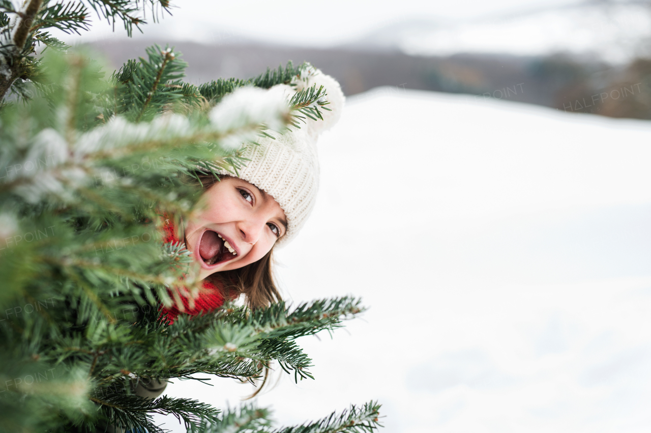 A small girl having fun in snow. Winter nature. Close up.