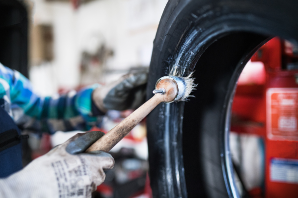 Female mechanic repairing a car. An unrecognizable woman working in a garage.