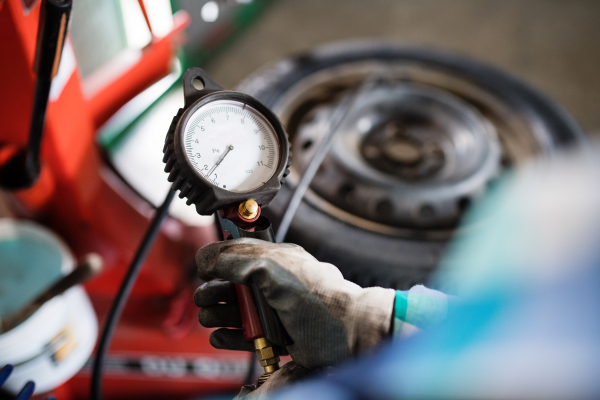 Female mechanic repairing a car. An unrecognizable woman working in a garage.