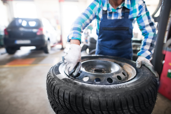 Unrecognizable female mechanic repairing a car. A woman working in a garage.