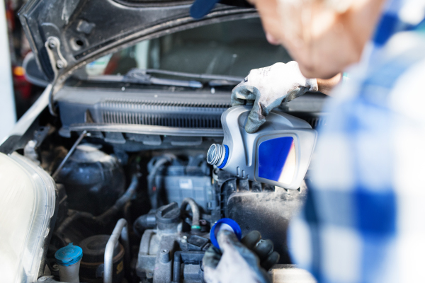 Unrecognizable female mechanic repairing a car. A senior woman working in a garage.