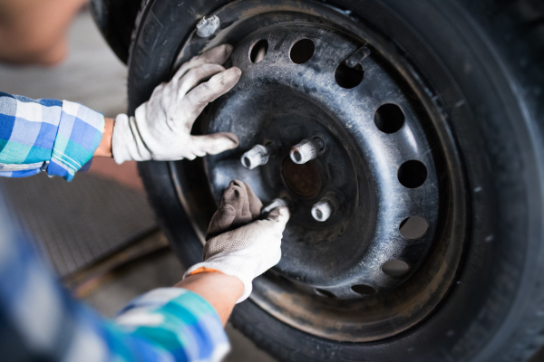 Female mechanic repairing a car. An unrecognizable woman working in a garage.