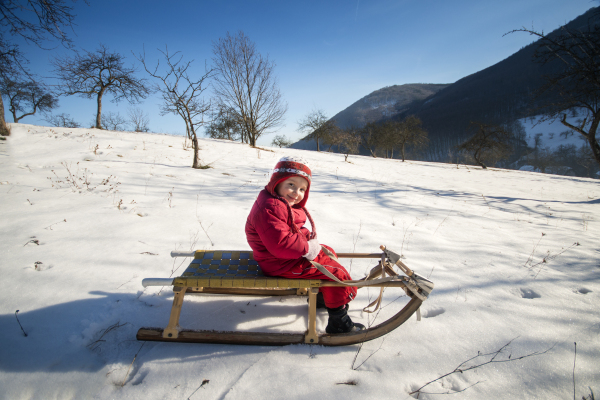 Little girl is playing outside in cold winter.