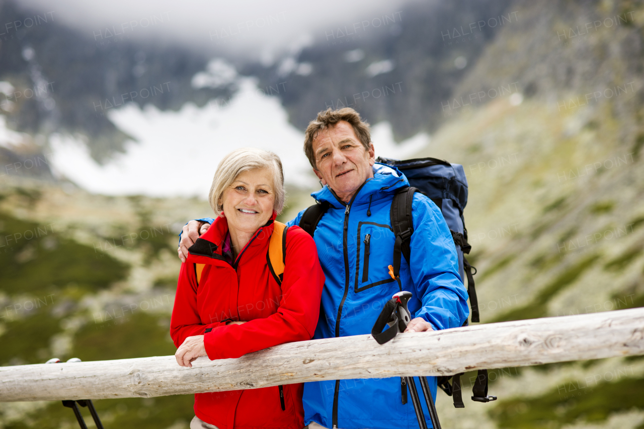 Beautiful senior couple of tourists in the mountains together, spring time.